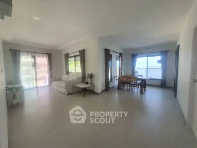 Spacious open-plan living and dining area with natural light and modern decor.