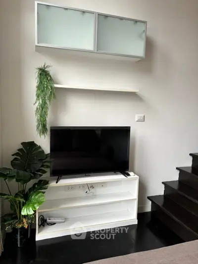 Modern living room with sleek TV setup and stylish shelving