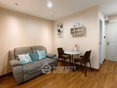 Cozy living room with sofa and dining table, perfect for relaxation and small gatherings.