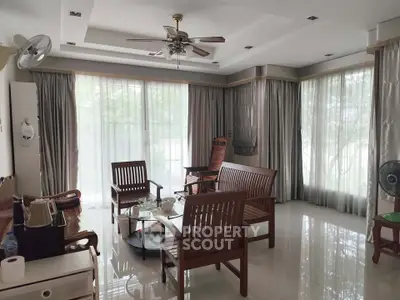 Spacious living room with elegant wooden furniture and large windows for natural light.