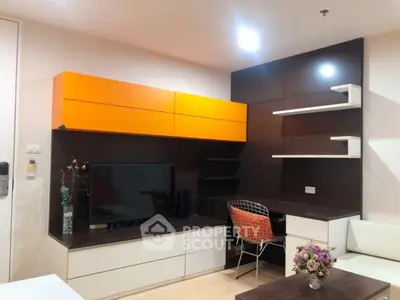 Modern living room with stylish orange cabinets and sleek TV setup.