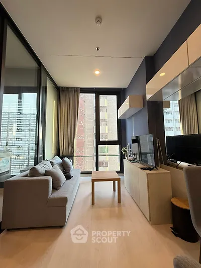 Modern living room with large windows and stylish furniture in a high-rise apartment.