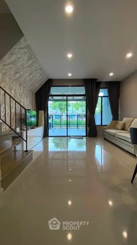 Spacious modern living room with large windows and elegant decor