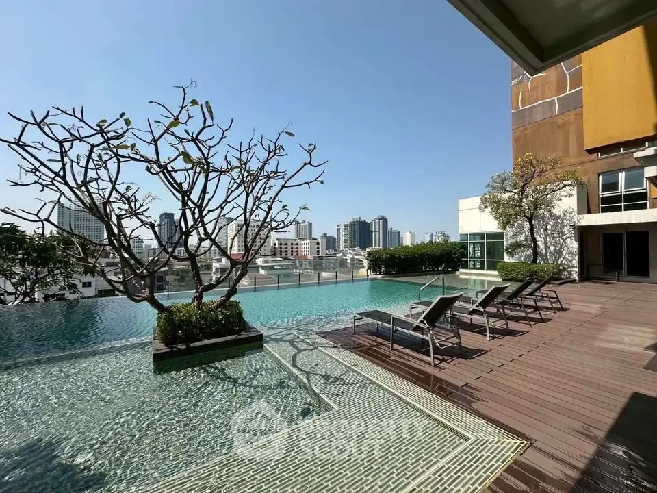 Luxurious rooftop pool with city skyline view and sun loungers, perfect for relaxation.