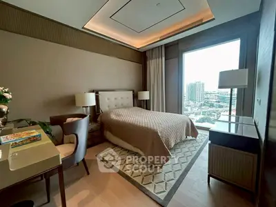 Luxurious bedroom with city view, elegant decor, and modern furnishings in high-rise apartment.