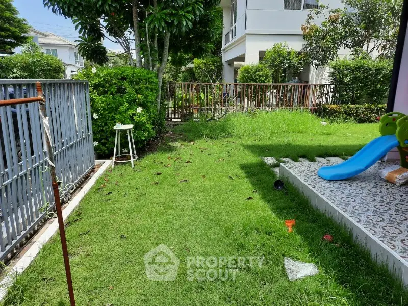 Charming garden with lush greenery and playful slide in a serene residential area.