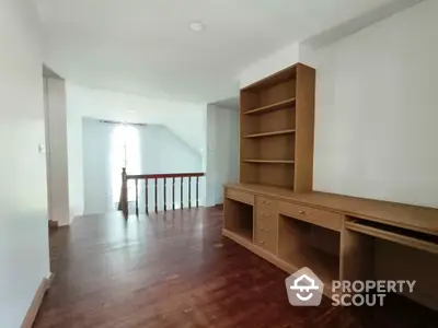 Spacious study area with built-in wooden shelves and natural light