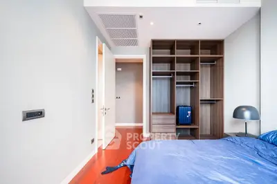 Spacious bedroom with modern wooden wardrobe and cozy blue bedding, perfect for relaxation.