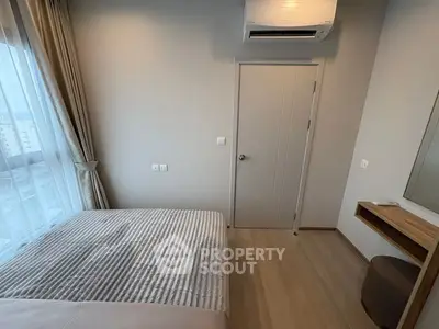 Modern bedroom with natural light, featuring a cozy bed, air conditioning, and minimalist decor.