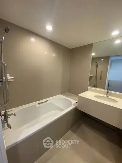 Modern bathroom with sleek design featuring a bathtub and elegant fixtures.