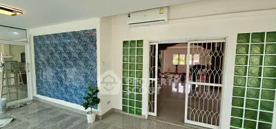 Spacious living room with unique glass block wall and air conditioning, perfect for modern living.