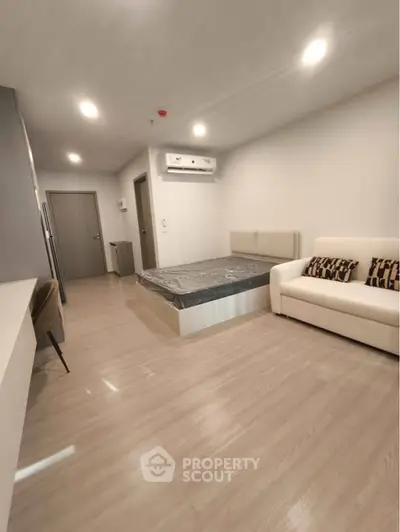 Modern studio apartment with sleek flooring and cozy furnishings.