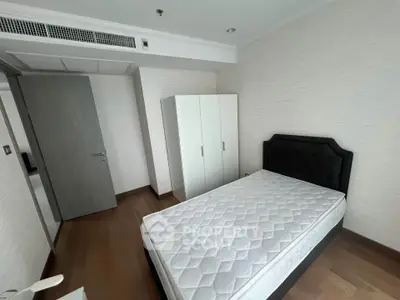 Modern bedroom with minimalist design featuring a comfortable bed and sleek wardrobe.