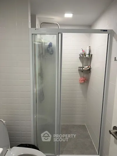 Modern bathroom with glass shower door and tiled walls