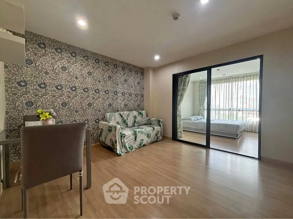 Spacious living room with floral decor and sliding glass doors to bedroom