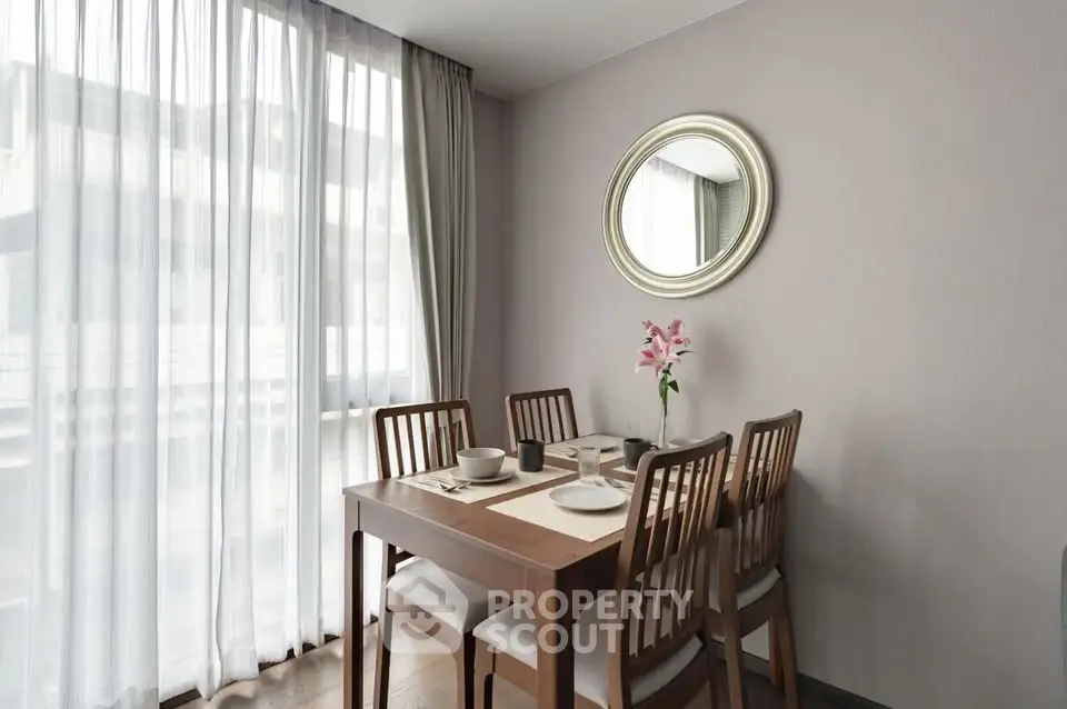 Elegant dining area with natural light and modern decor in a stylish apartment.