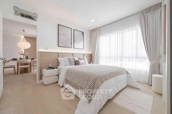 Bright and spacious bedroom with modern decor and large window for natural light.
