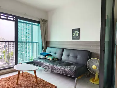 Modern living room with sleek black sofa, large window, and balcony view in urban apartment.
