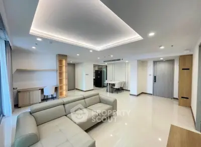 Spacious modern living room with elegant lighting and sleek furniture in a contemporary apartment.