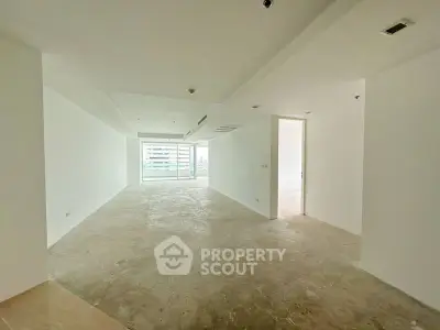 Spacious open-plan living area with large windows and city view, perfect for modern urban living.