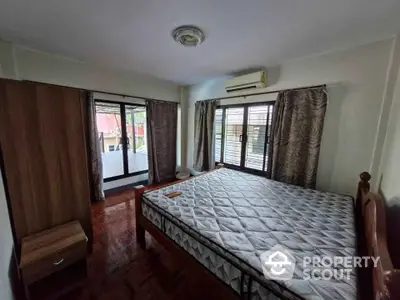 Spacious bedroom with large windows and balcony access