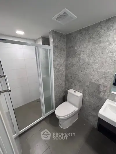 Modern bathroom with sleek shower and elegant gray tile design.