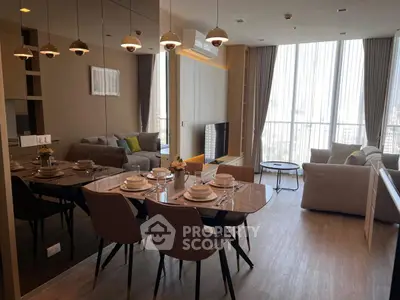 Modern open-plan living and dining area with elegant decor and large windows.