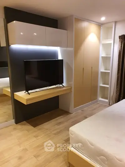 Modern bedroom with sleek TV setup and ample storage space