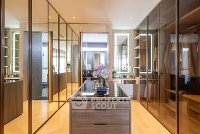 Luxurious walk-in closet with mirrored doors and elegant wooden finishes