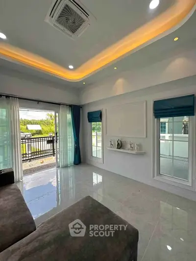 Spacious modern living room with large windows and elegant ceiling lights