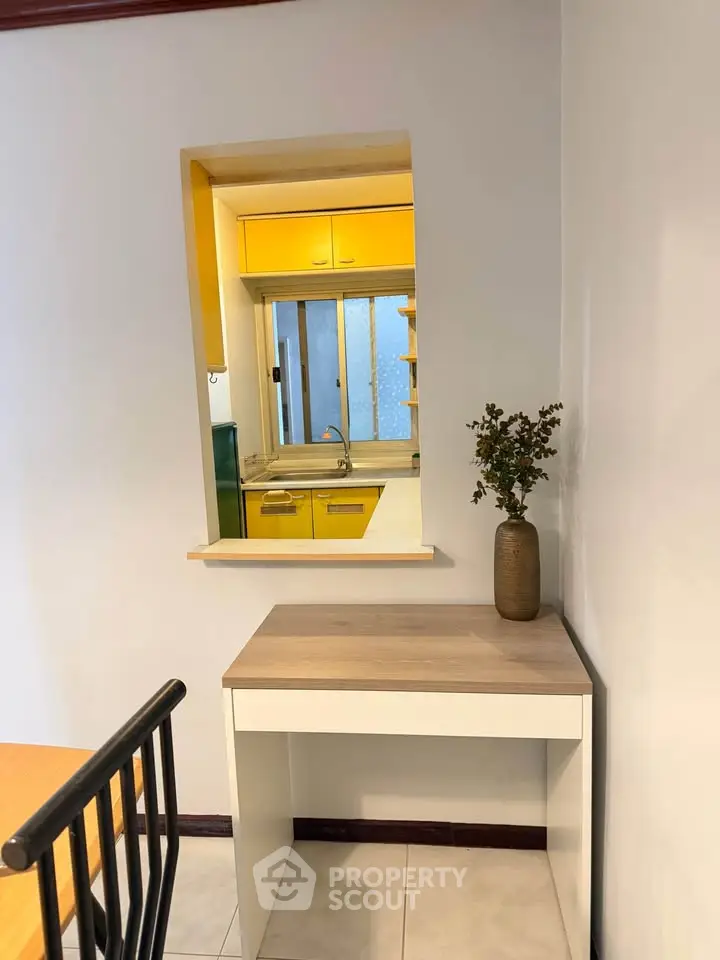 Charming kitchen with vibrant yellow cabinets and a cozy dining nook, perfect for modern living.