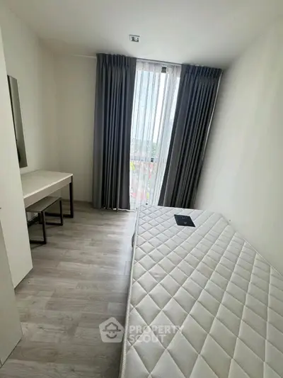 Cozy minimalist bedroom with large window and modern furnishings.