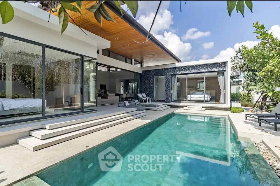 Luxurious modern villa with private pool and spacious outdoor area under clear blue skies.