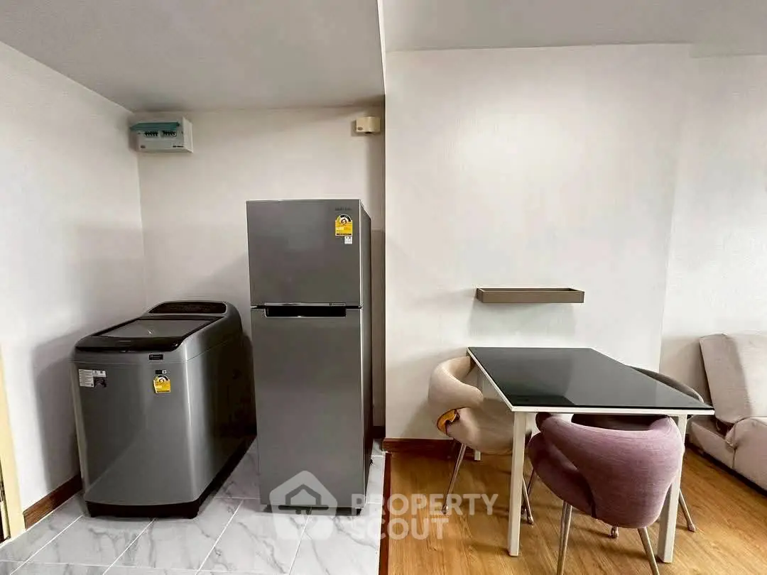 Modern apartment interior with sleek kitchen appliances and stylish dining area.