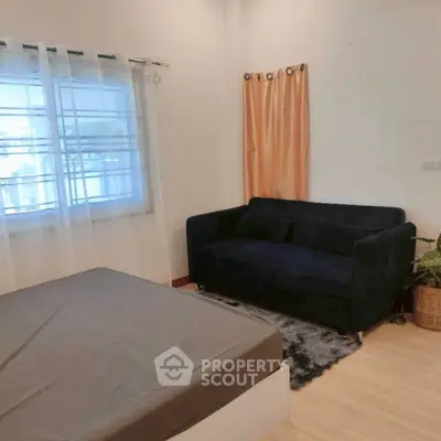 Cozy bedroom with stylish navy sofa and natural light