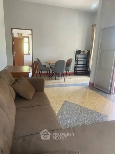 Spacious living room with modern furniture and natural light, perfect for relaxation and entertaining.
