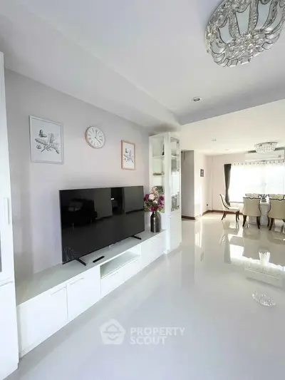 Spacious modern living room with elegant dining area and sleek white furnishings.