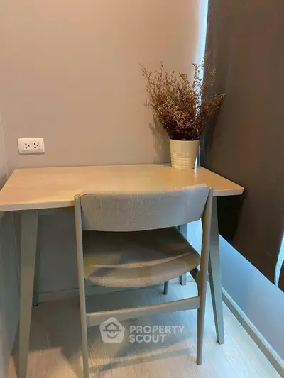 Cozy study nook with a desk, chair, and decorative plant in a modern apartment.