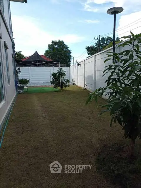 Spacious backyard with lush greenery and privacy fencing in a serene neighborhood.