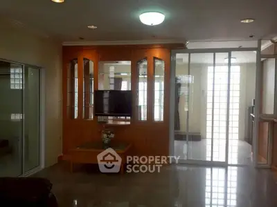 Spacious living room with elegant wooden cabinetry and modern glass doors