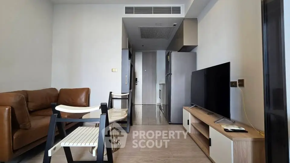 Modern living room with sleek furniture and open kitchen layout in a stylish apartment.