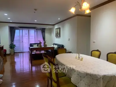 Spacious living room with elegant dining area and cozy seating, featuring warm lighting and polished wooden floors.