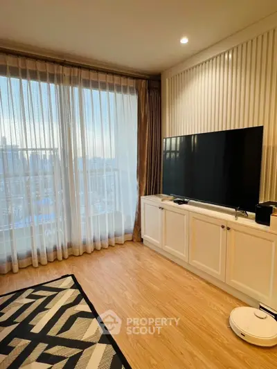 Modern living room with large TV and elegant curtains in a bright apartment