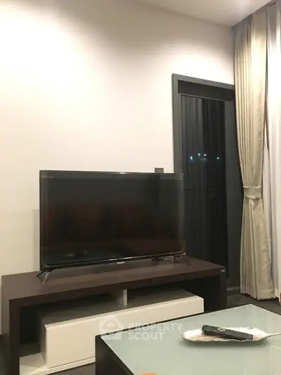 Modern living room with sleek TV setup and elegant curtains, perfect for cozy evenings.