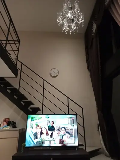 Modern duplex living room with elegant chandelier and stylish staircase