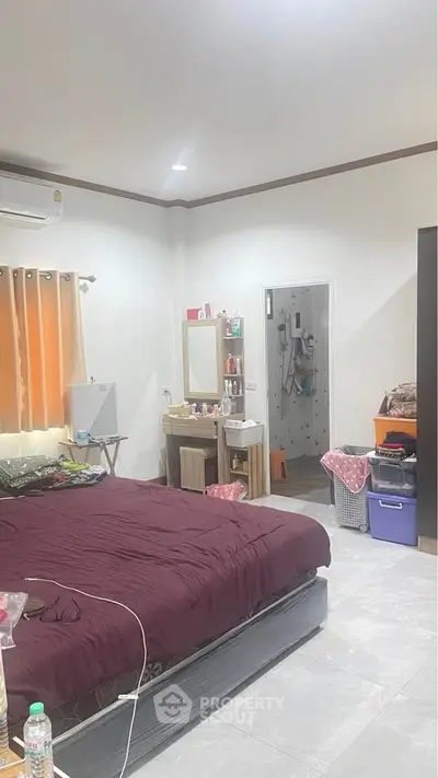 Cozy bedroom with modern decor and ensuite bathroom, featuring ample storage and natural light.