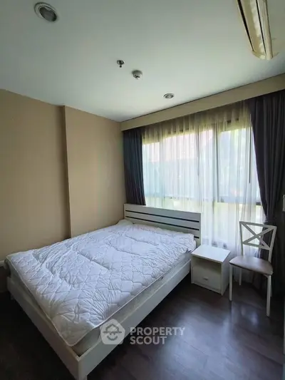 Cozy bedroom with natural light and modern furnishings in a stylish apartment.