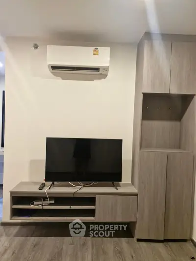 Modern living room with sleek TV stand and air conditioning unit, perfect for comfortable living.