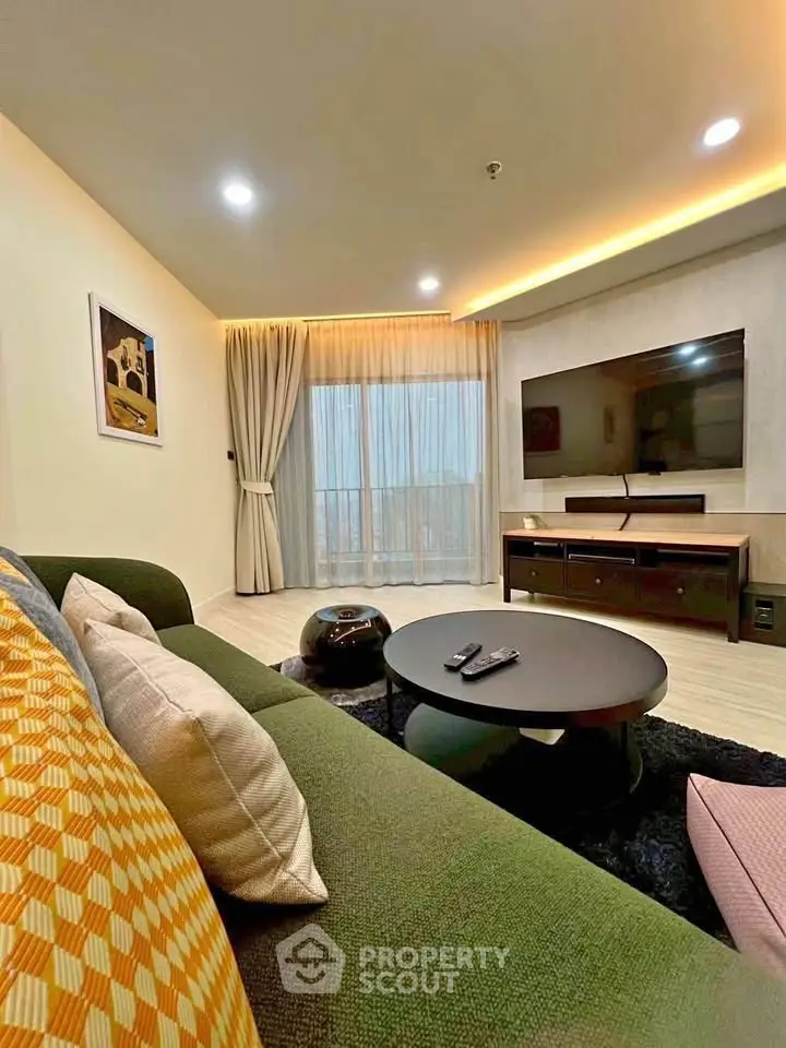 Modern living room with stylish decor, large TV, and cozy seating area, perfect for relaxation.