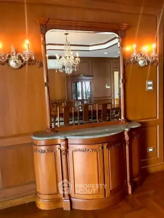 Elegant wooden interior with chandelier and classic mirror in luxury home.
